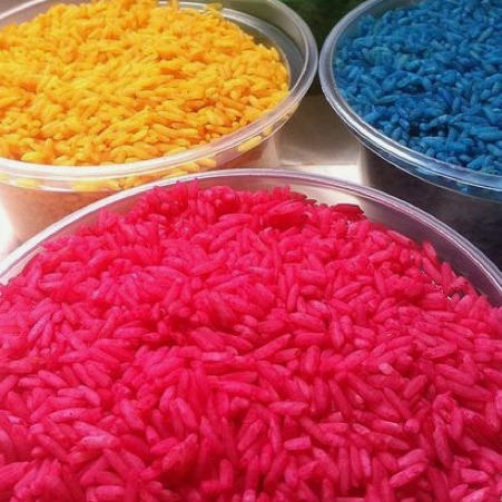 Tubs of yellow, blue and pink scented sensory rice.