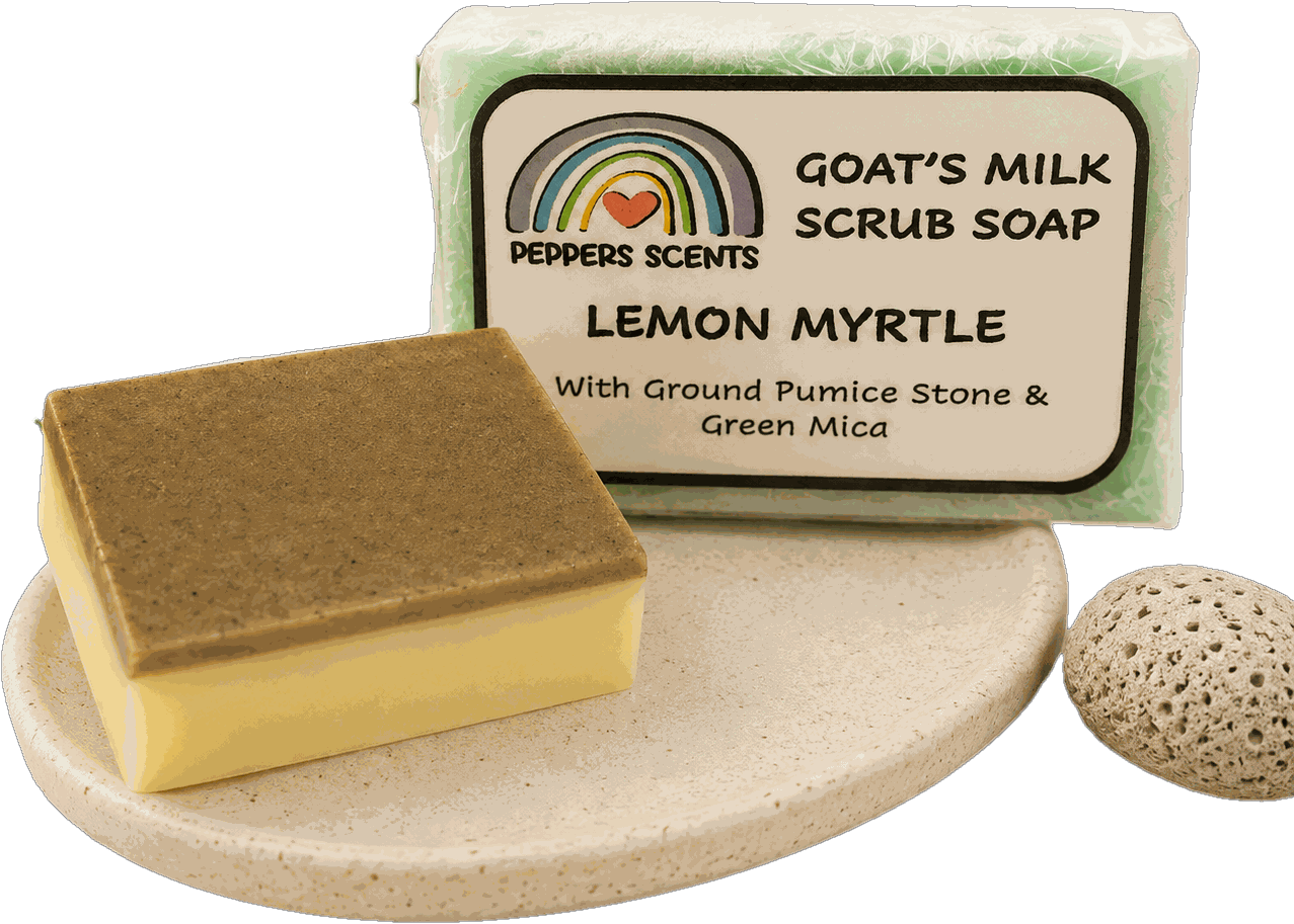 A wrapped Lemon Myrtle goat's milk scrub soap beside an unwrapped bar showing its ground pumice scrub layer.